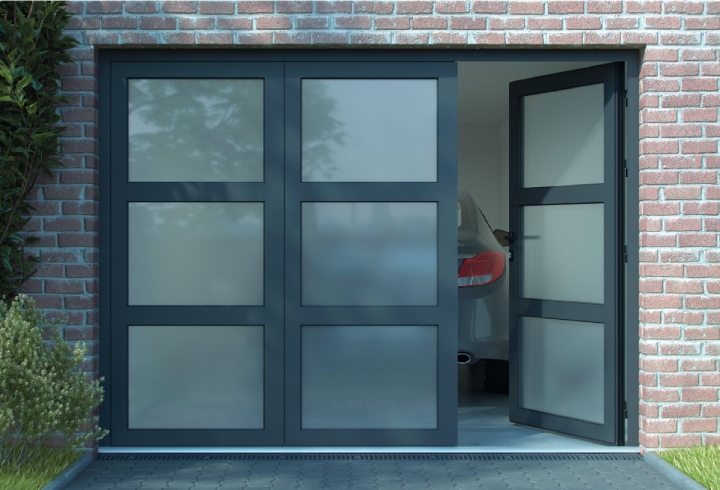 porte de garage en aluminium noir avec grands carreaux vitrés et porte d'accès sur maison en pierre, élégance et charme.